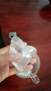Buz kişinin elindedir ve buzla dolu bir bardağa bira dökerler..