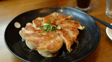 Siyah bir tabak üzerinde Japon gyoza.
