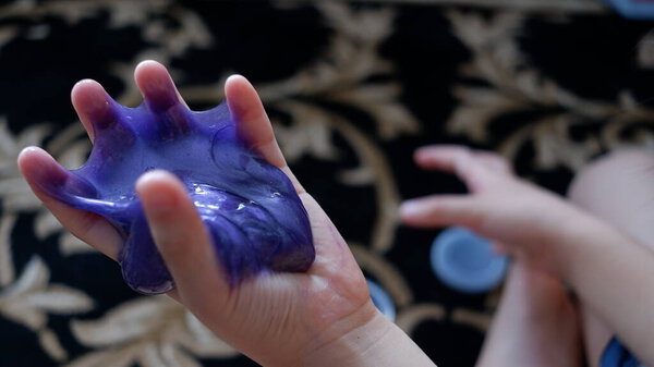 Маленькая девочка играет со слизью дома