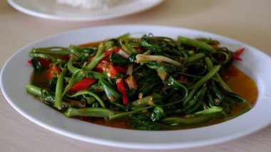 stir-fried water spinach with Tauco on a white plate with rice. Tumis kangkung Tauco. Indonesia Food.