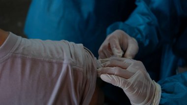 health worker injects vaccine into patient's arm for Covid-19 Vaccine booster. A vaccination concept photo.