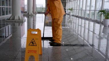 Sarı alarm, MRT istasyonunda ıslak zemin tabelası tehlike görüntüsü, açık alanda temizlik yapılıyor. Jakarta, 9 Nisan 2022.