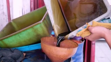 Repair shop staff is pouring car oil. Shop n Drive, Jakarta. 14 August 2022.