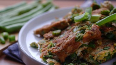 Beyaz bir tabakta nohutla pişirilmiş yumurtalar.