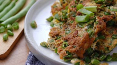 Beyaz bir tabakta nohutla pişirilmiş yumurtalar.