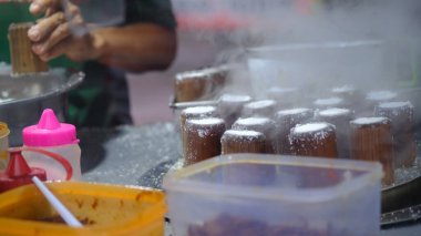 Geleneksel bambu putu pasta satıcısı. Putu, içi palmiye şekeriyle dolu pirinç unundan yapılır. Endonezya yemekleri.