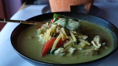 Masadaki siyah tabakta Tayland usulü yeşil köri..