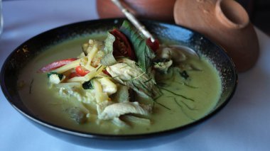 Masadaki siyah tabakta Tayland usulü yeşil köri..