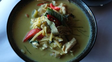 Masadaki siyah tabakta Tayland usulü yeşil köri..