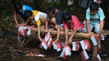 Childrean, Endonezya 'nın bağımsızlık günü için uçurtma ve bayrak yapıyor. Muncul, Güney Tangerang şehri. 14 Ağustos 2022.