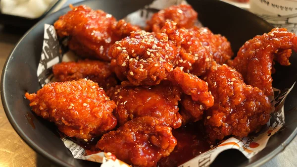 Soya ve baharatlı Kore kızarmış tavuğu siyah tabakta..