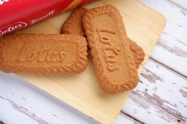 Lotus Biscoff bisküvisi ahşap tepside beyaz arka planda. 