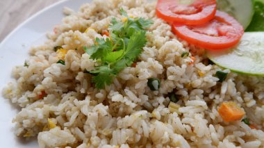 Yang Chow pilavı, beyaz tabakta domates ve salatalık dilimlenmiş..