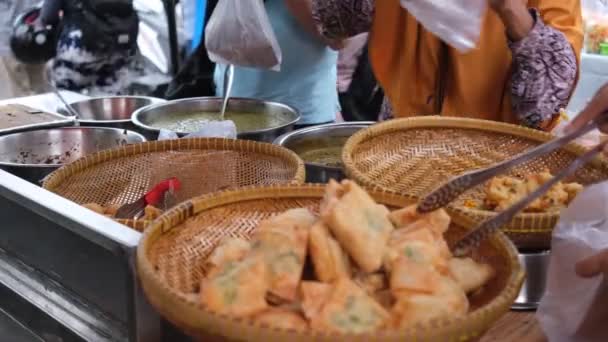伝統的な市場で揚げた食品を購入している売り手と買い手の間の取引 — ストック動画