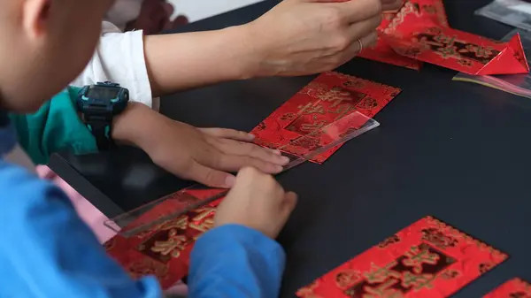 Craft workshop make Chinese lanterns from red envelop papers.