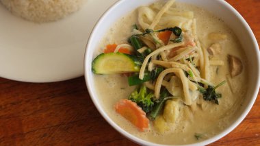 Masadaki beyaz kasede yeşil köri..