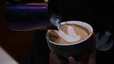 Latte sanatının nasıl yapıldığını gösteren bir barista..