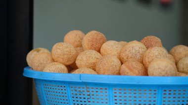 Golgappa or Pani Puri is a deep-fried breaded hollow spherical shell, about an inch (2.5 cm) in diameter, on a plastic basket. clipart