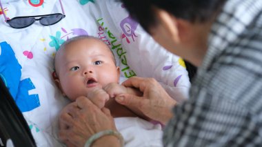 Bebek arabasında bebekle oynayan bir büyükanne.. 