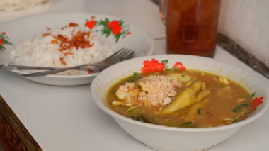Dilimlenmiş tavuklu tavuk çorbası, tavuk ayağı, yumurta, dilimlenmiş lahana, et suyunda vermicelli. Endonezya yemekleri.