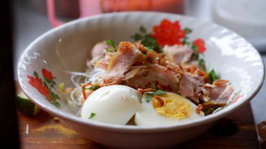 Endonezya tavuk çorbası malzemesi. Haşlanmış yumurta, doğranmış tavuk, vermicelli, domates, lahana, kereviz, baharatlı sarı soslu kızarmış soğan..