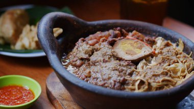 Üstü doğranmış tavuk, pindang yumurtası, tofu, krecek ve kil çömlek üzerinde meyveli Gudeg lapası. Gudeg, Jogja 'nın geleneksel mutfağıdır.. 