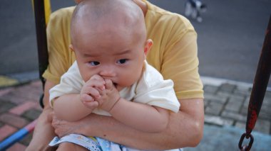 6-7 aylık tatlı bir bebek. Parmağını ağzına sokmuş. Parmağını emen bir bebek. Jakarta, 27 Mart 2025.