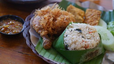 Nasi Bakar, baharat ve malzemelerle tatlandırılmış, muz yaprağına sarılmış ve daha sonra mangal kömürü ile kızartılıyor. Endonezya yemekleri.