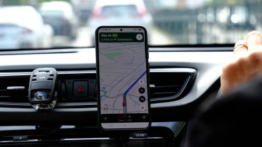 Bir sürücü, paralı yoldaki bir arabada akıllı telefondaki Google haritalarını kullanıyor. Sydney, 8 Ocak 2023.