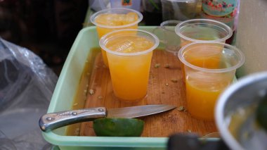 Geleneksel portakal suyu satıcıları elle sıkma araçları kullanırlar.