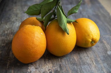 Portakallar ve yaprakları arka planda eski tahtalar, yakın cephe manzarası