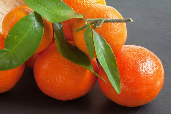 Clementines ve yaprakları arka planda