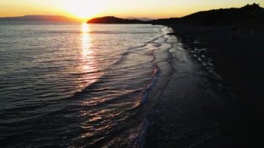 Gün batımında İHA uçuşu Ege 'deki deniz taşları ve kumsalda görülebilir.