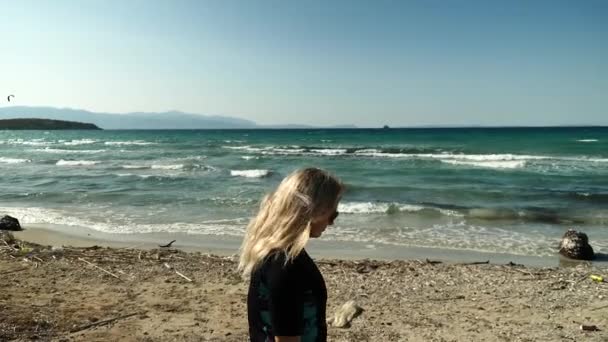 ビーチで壁にぶら下がっている若い美しい少女 — ストック動画