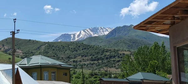 Kışın Chimgan Dağı Özbekistan 'da güneşli, soğuk bir günde ve karla kaplı bir evde. Yüksek kalite fotoğraf