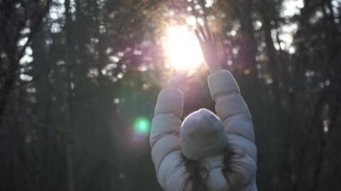 Elleri havada, kışın ormanda açık havada dans eden bir kızın dikiz görüntüsü. Yüksek kalite 4k görüntü