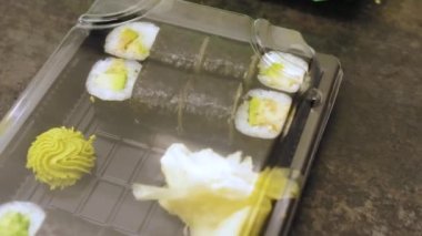 Suşi ve rulo plastik bir kutuda. Teslimat servisi, yemek stoku görüntüleri. Yüksek kalite 4k görüntü