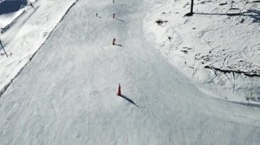 Güneşli bir günde beyaz, karlı bir yamaçta uçan kış sporcularının görüntüsü. Yüksek kalite 4k görüntü