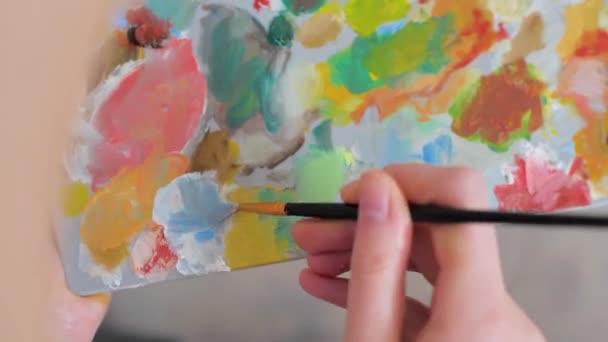 女孩的手把绘画与调色板上的画笔混合在一起 高质量的4K镜头 — 图库视频影像