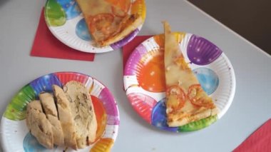 Ev yapımı pizza, peynirli, domatesli, kağıt tabakta, parti masasında. Yüksek kalite 4k görüntü
