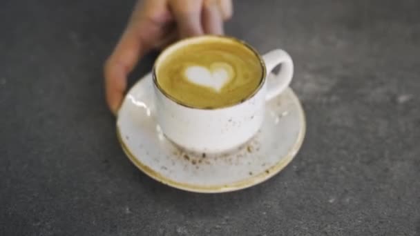男人的手把卡布奇诺杯放在桌上 心形放在咖啡上 优质Fullhd影片 — 图库视频影像