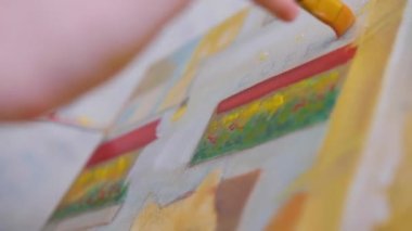 Başarılı bir ressam, modern bir yağlı boya resim yapıyor. Çadır bezi üzerine modern sanat eseri, yaratıcı, çağdaş ve başarılı güzel sanatçılar, başyapıt çizerler. Yüksek kalite 4k görüntü