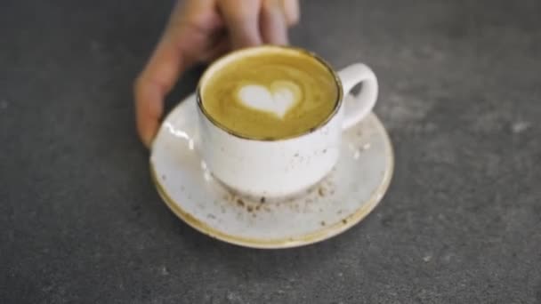 男人的手把卡布奇诺杯放在桌上 心形放在咖啡上 优质Fullhd影片 — 图库视频影像