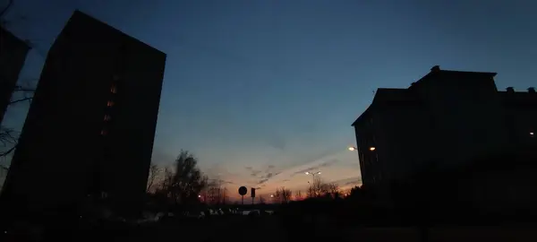 Mavi göl suyundaki günbatımı saatinde ağaçların ve binaların Sillouhet yansıması. Yüksek kalite fotoğraf