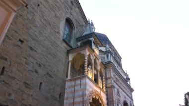 Bergamo Katedrali 'nin sıcak bir akşam ışığında karmaşık taş mimarisini gösteren detaylı bir görüntüsü..