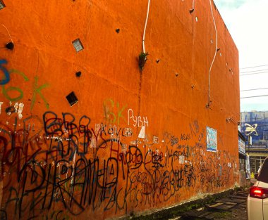 Binanın duvarları grafiti ile kaplanmış gibi görünüyor, kirli olduğu izlenimini veriyor.