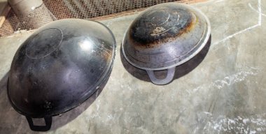 Evin duvarında demirden yapılmış bir tavanın asılı olduğunu görebilirsiniz. Bu tava genellikle büyük ölçekte yemek pişirmek için kullanılır..