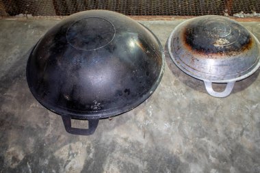 Evin duvarında demirden yapılmış bir tavanın asılı olduğunu görebilirsiniz. Bu tava genellikle büyük ölçekte yemek pişirmek için kullanılır..