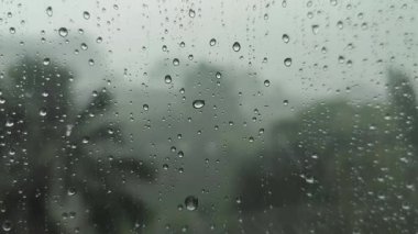 Hafif sisli arka planı olan bir binanın camına yağmur yağar