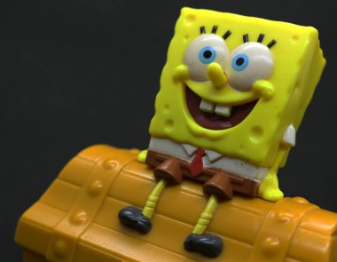 Sünger Bob oyuncağı ve hazine sandığı, siyah arkaplan.